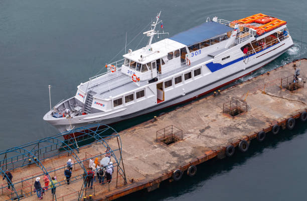 белый пассажирский катер пришвартовывания на набережной, крым - editorial sea white ship стоковые фото и изображения