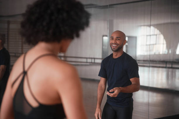 African-american male dancer smiling in studio with teacher Happy african-american male dancer smiling in studio with teacher during rehearsal class dance studio instructor stock pictures, royalty-free photos & images
