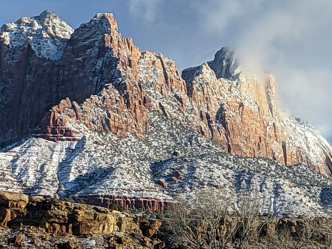 Sun rises over Mt Kinesava in Zion National Park and new snow in early morning