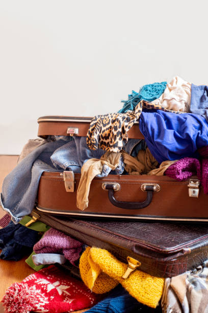 istock Old suitcases overflowing with second-hand clothes on the floor. Sorting wardrobe and textiles. Cleaning the wardrobe. Sustainable life 1298678853