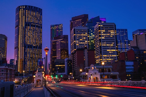 A view of light trails from cars illuminated roads leading towards downtown Calgary at night.