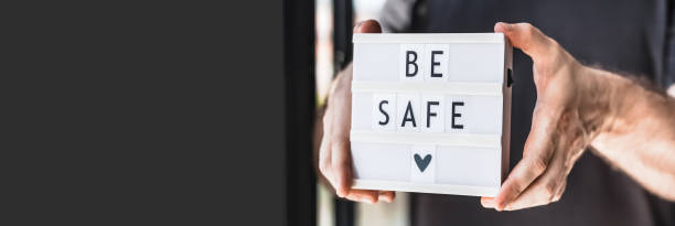 istock Man holding lightbox with text Be safe in his hand 1298680911