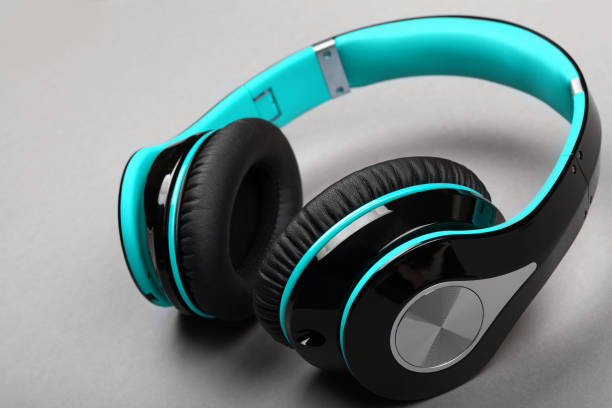 istock Close up modern teal headphones on gray table 1298681569