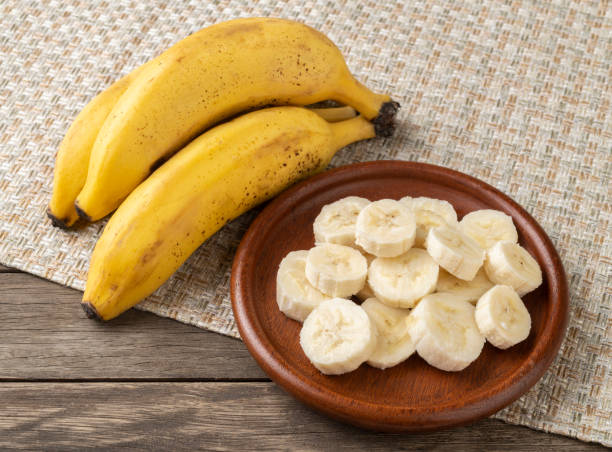 istock Bananas and slices on a plate over wooden table 1298682434