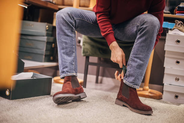 istock Man trying on new shoes using shoehorn 1298683516
