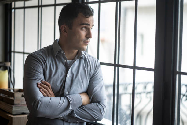 istock Young businessman standing next to the window 1298685299