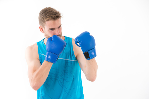 Sportsman in boxing gloves isolated on white background. Trainer or coach man in defense position. Power and energy. Sport activity or training and workout in gym.
