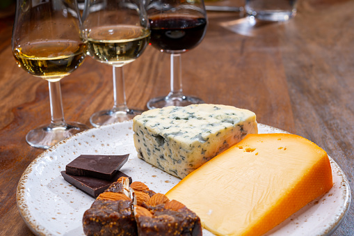 Tasting and pairing of different cheeses with strong alcoholic drinks, whisky, cognac or calvados close up