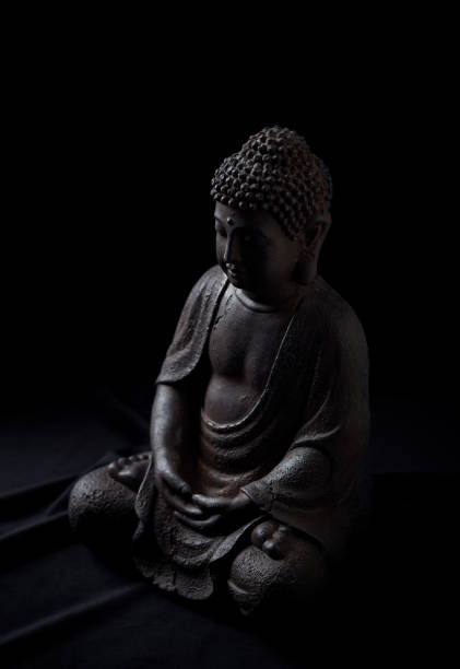 istock Meditating Buddha Statue isolated on black background. 1298689710
