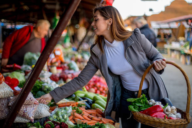 istock Woman is putting vegetables in basket. 1298691578