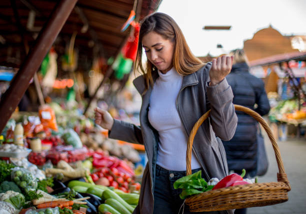 istock Young lady is holding basket, buying fresh vegetables. 1298691689