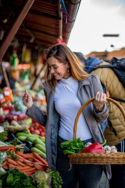 istock Young woman is choosing fresh vegetables. 1298691741