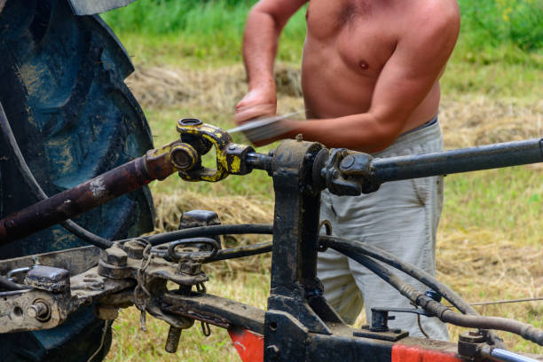 tractor and cardan shaft for coupling equipment, tractor in the field during haymaking. - agricultural machinery retro revival summer farm imagens e fotografias de stock