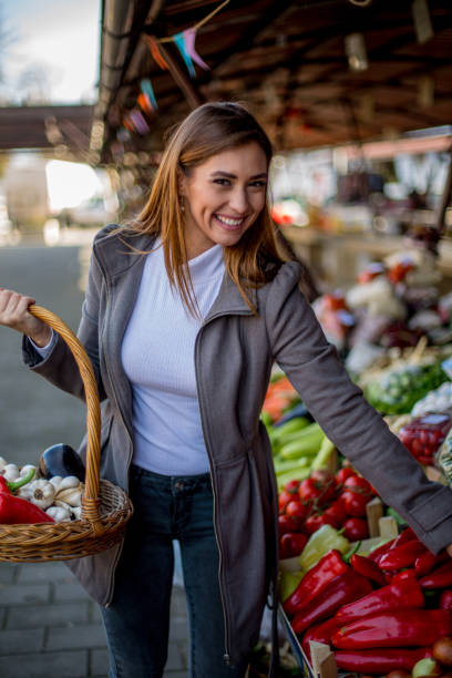 Young woman is buying peppers.