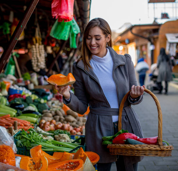 istock Young woman buying pumpkin. 1298693518