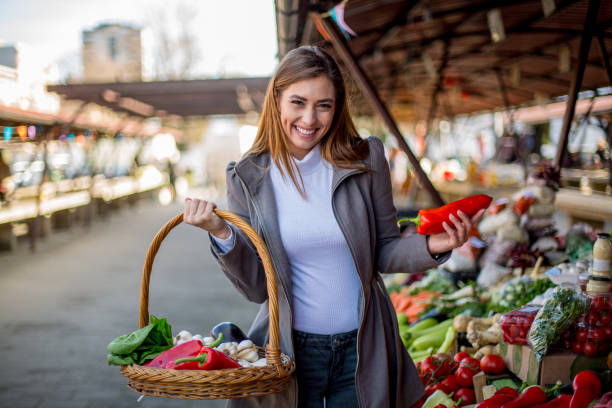 istock Lovely lady is going around market, buying vegetables. 1298693586