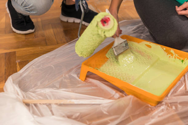 istock Dipping painting tools in a tray with lime green paint 1298695861