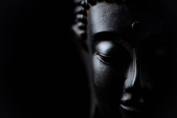 istock Meditating Buddha Statue isolated on black background. Copy space. 1298696548