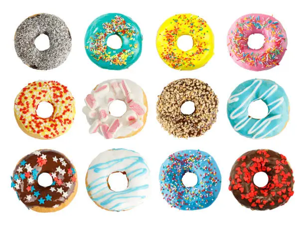 Photo of Set of 12 different colorful donuts isolated on white background. View from above.