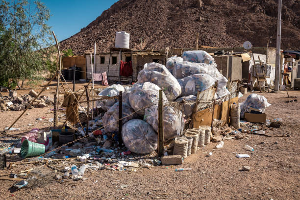 pile of garbage bags with different garbage in desert