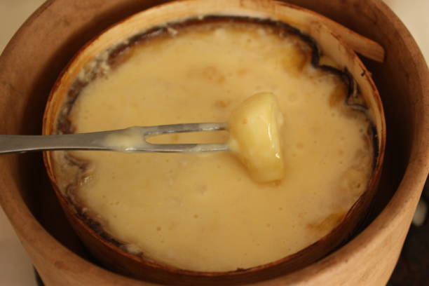 istock Cheese fondue being cooked   Bread dipped in melted cheese 1298704090