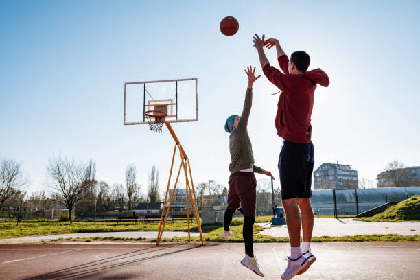 istock Millennials playing basketball outdoors in winter or autumn 1298708118
