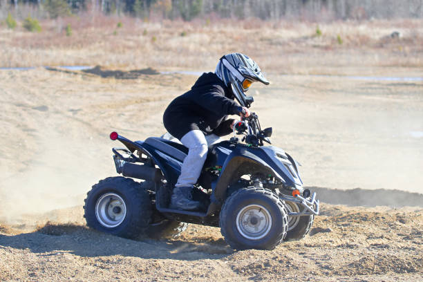 Young men driving quad on the hill