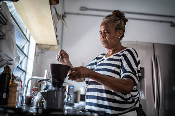 istock Mature woman preparing coffee at home 1298714645
