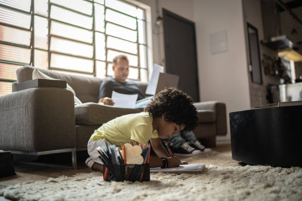 istock Boy drawing and his father working on background at home 1298715061