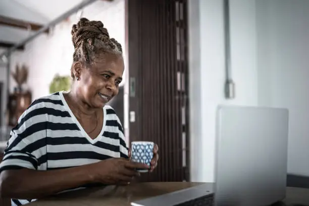 Photo of Mature woman at home using laptop