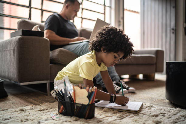 istock Boy drawing and his father working on background at home 1298715109