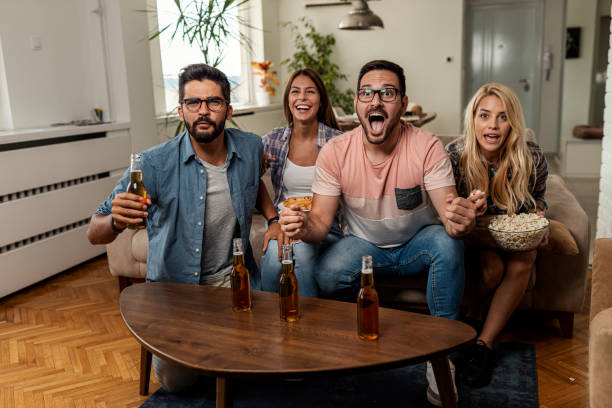 istock Friends watching sport on tv 1298715575