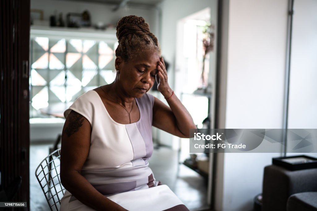 Mature woman with headache at home Senior Adult Stock Photo