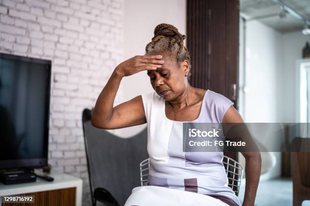 Mature Woman With Headache At Home Stock Photo - Download Image Now - Dizzy, Senior Adult, Senior Women