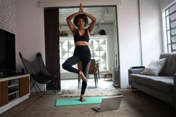 istock Young woman at home doing yoga 1298716569
