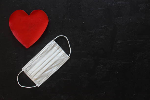 istock Red plush heart with face mask on stone background. Top view, copy space. Valentines day concept. 1298722937