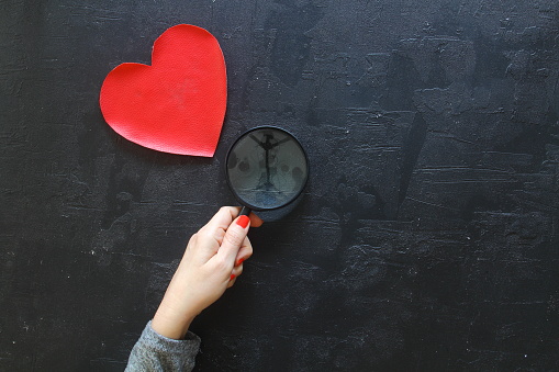 person holding magnifying glass and search love