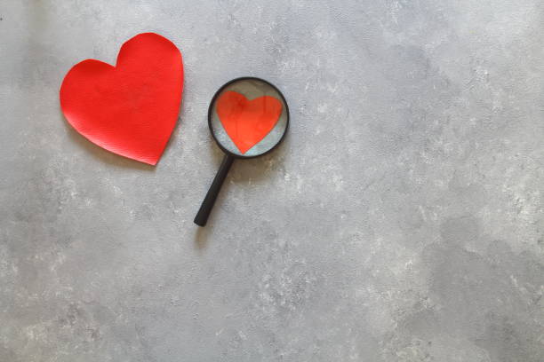 istock red heart and magnifying on a white background 1298725175