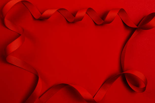 istock Classic red background. Ribbon`s frame. A delicate red wavy ribbon on a red background. Image for your text. 1298730104