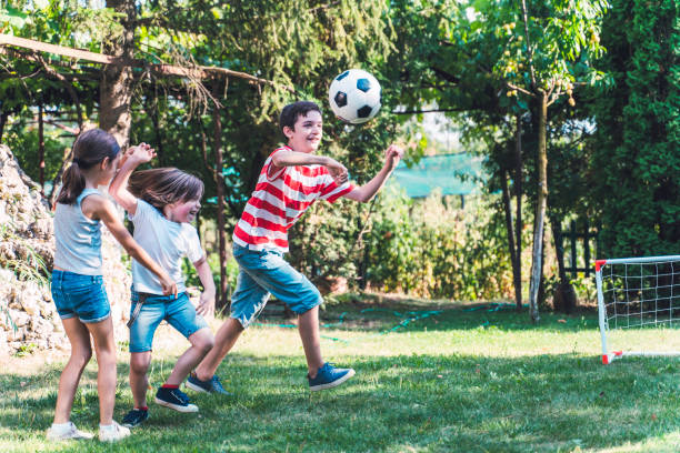 istock Happy children playing soccer in the back yard. 1298732595