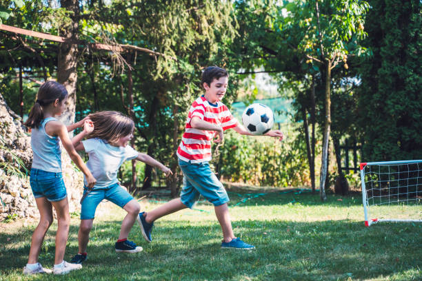 istock Happy children playing soccer in the back yard. 1298732599
