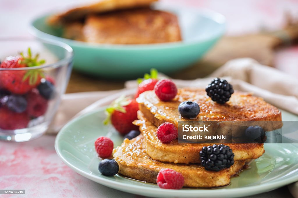 French Toast with Berries and Maple Syrup Preparing french toast flavored with fresh berry fruits and drizzled with maple syrup French Toast Stock Photo