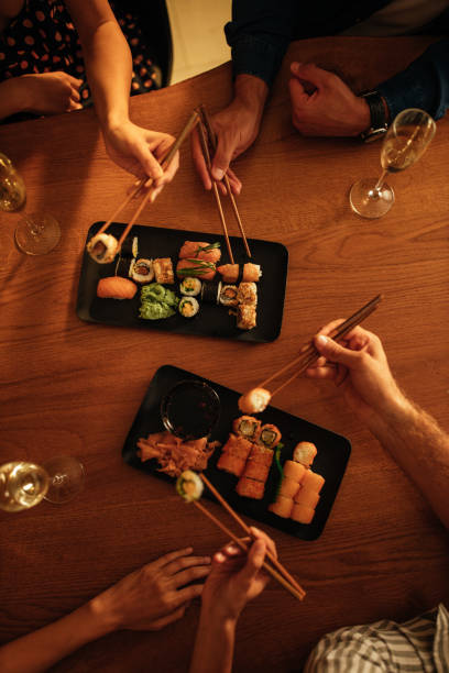 istock Close up of people eating sushi 1298736005