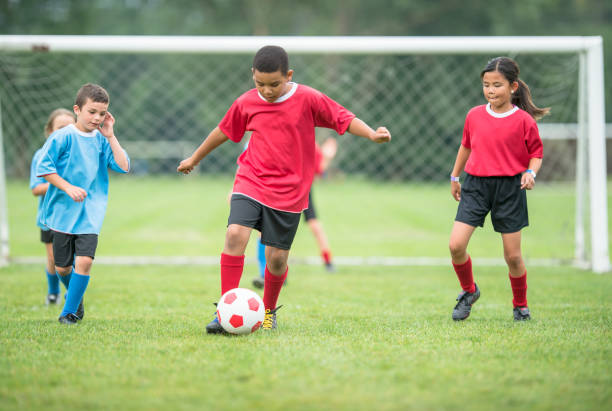 istock Boy playing soccer on the field 1298736038