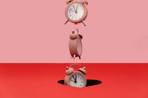 istock Alarm clock is falling trough the hole. 1298750234
