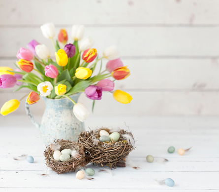 Vintage Easter Tulips and Easter Eggs on an Old White Wood Background