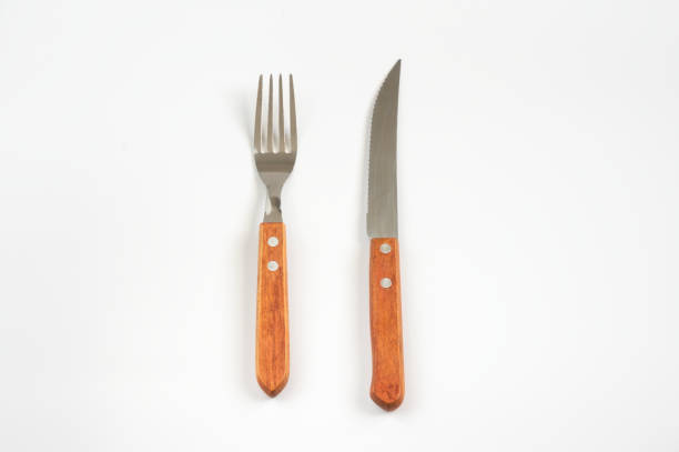 istock Fork and knife using for eat food meal on white. 1298757428