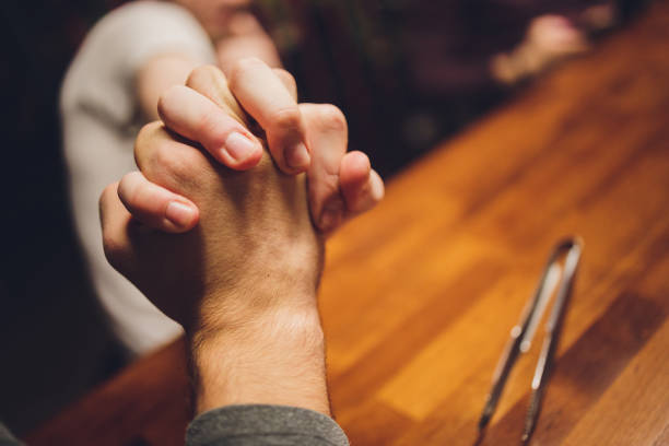 istock Close up male and female holding hands over table. 1298757641
