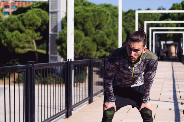 istock handsome sportsman resting exhausted on his knees 1298757818