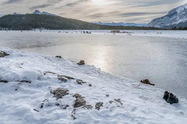 Boots on the banks of frozen Lake Minnewanka in Banff National Park, Alberta, Canada